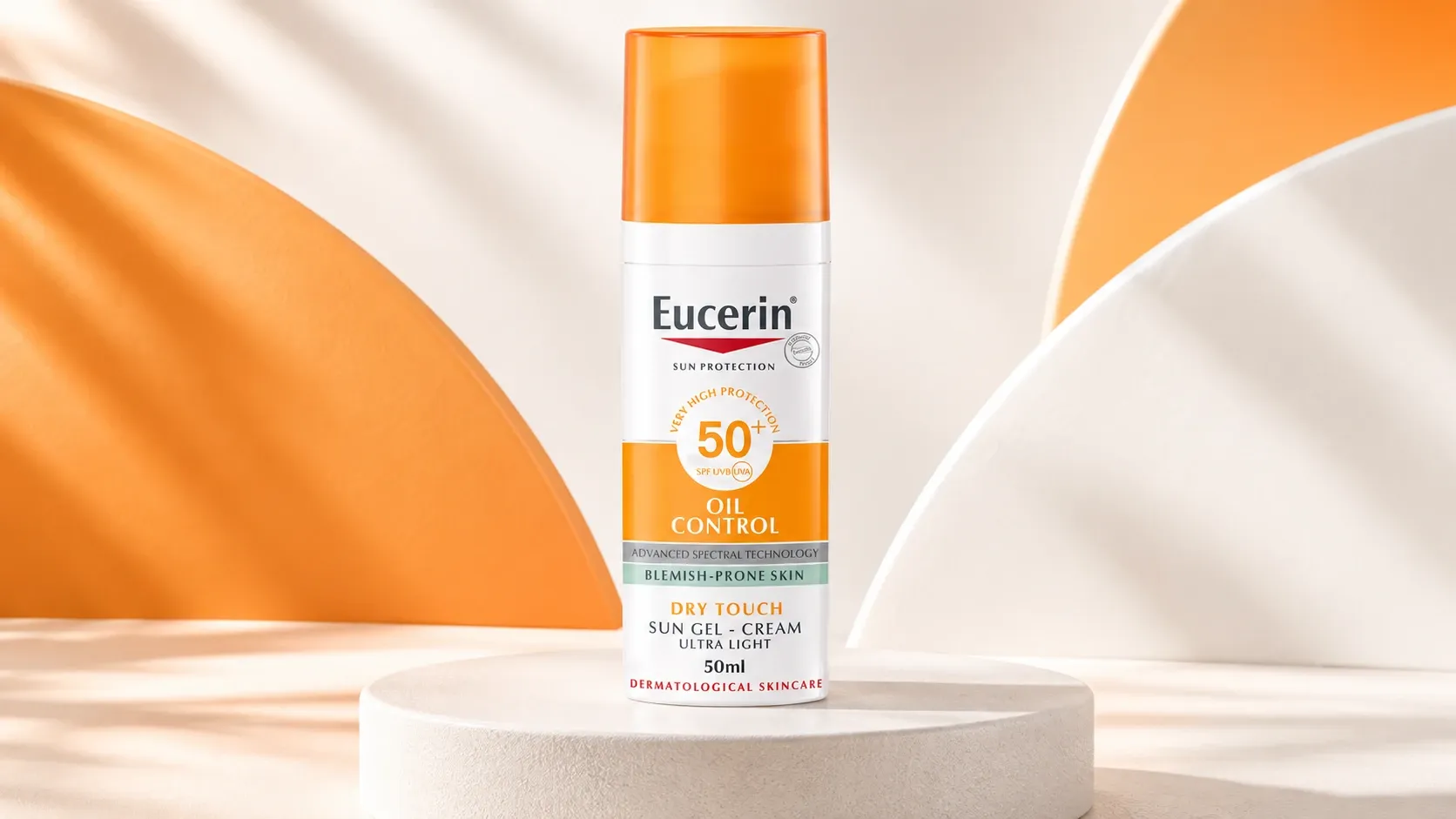 واقي شمس يوسيرين اويل كنترول +SPF 50 في مقدمة مشهد مائي لامع مع رذاذ وقطرات حول العبوة.